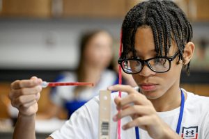 Middle School student measuring liquid.