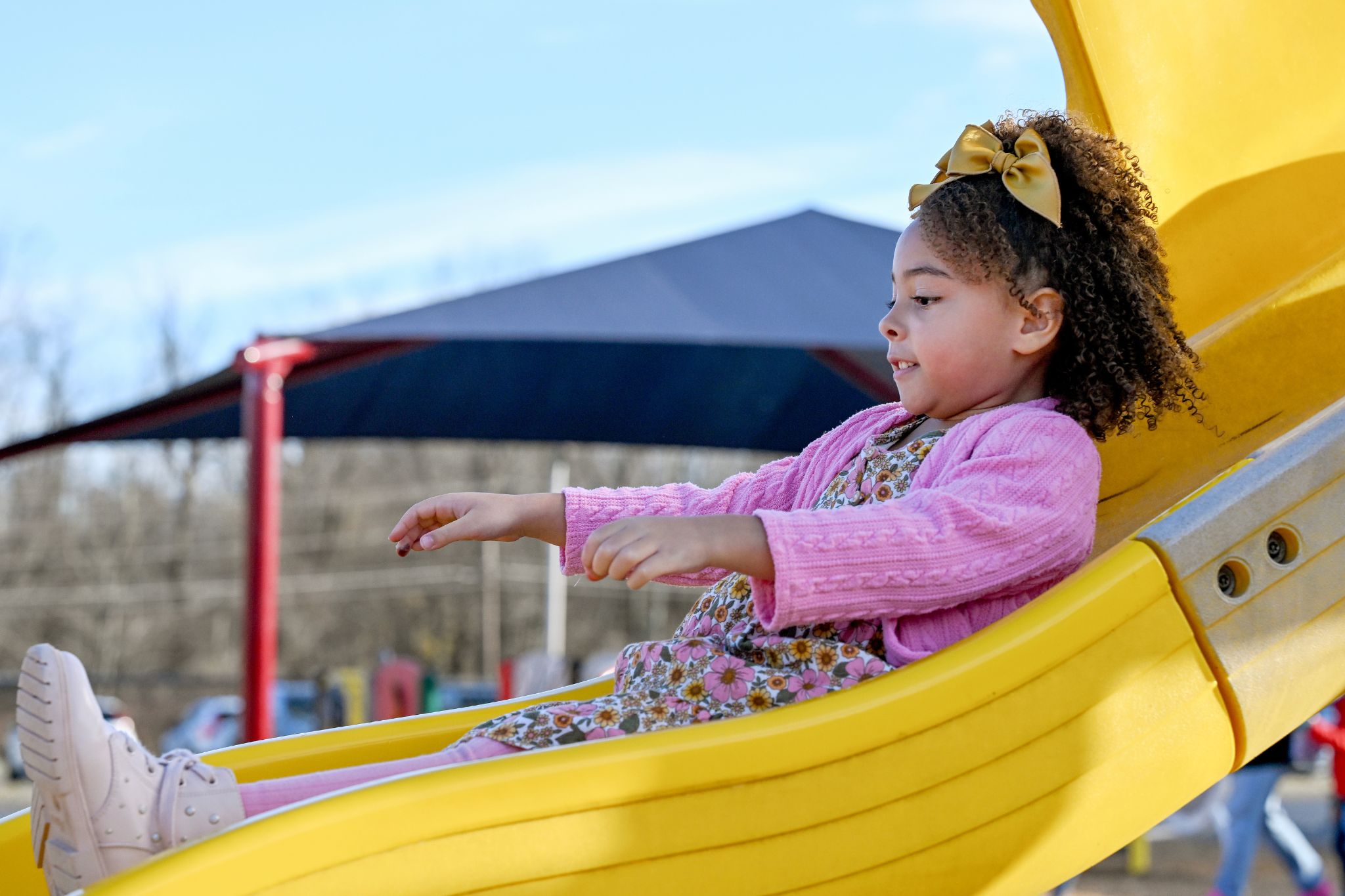 A student goes down the slide at the playground.