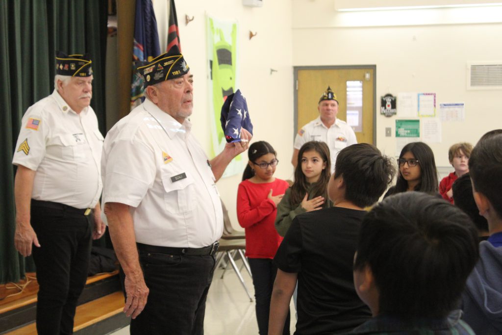 American Legion, Post #1181 members demonstrate the proper way to fold a flag to fourth graders at East Coldenham Elementary School.