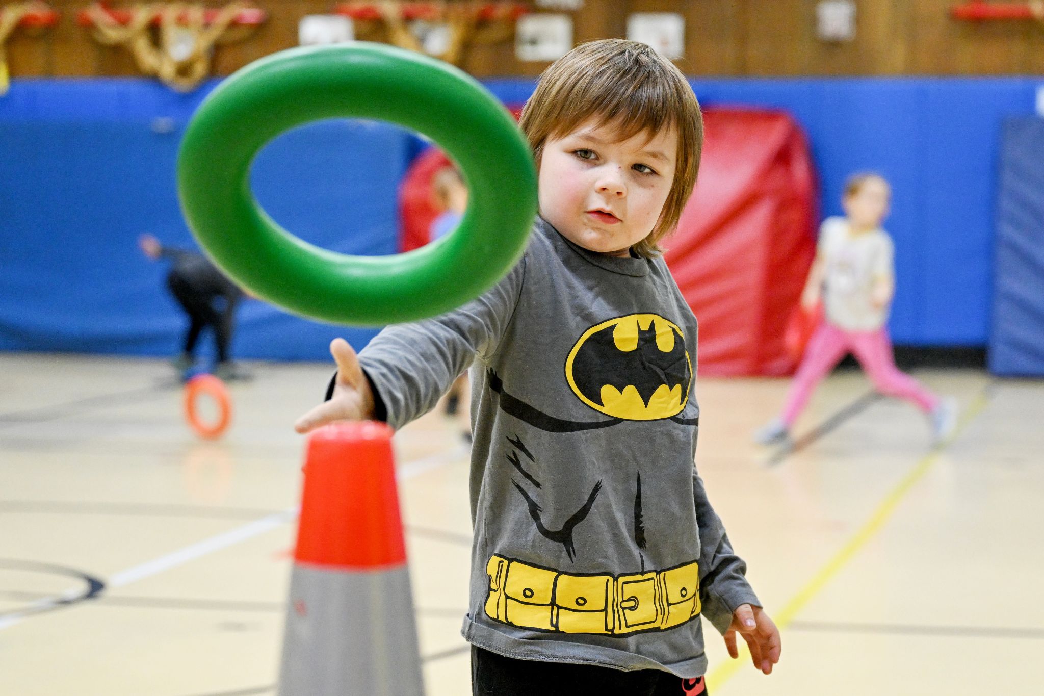 A student throws a ring at a traffic cone during a game in physical education class.