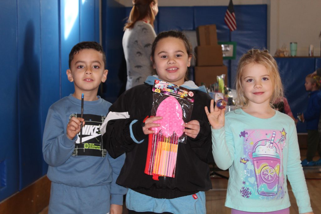 (L to R) Marcos Vazquez, Gamila Mohamed, and Addison Archer show off the prizes they bought at the school store using their Viking Bucks.